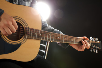 Fototapeta na wymiar Musician plays guitar on black background, close up