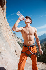 Handsome male rock climber drink water