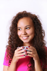 Close up portrait of pretty young woman in pink shirt drinking coffee on white background