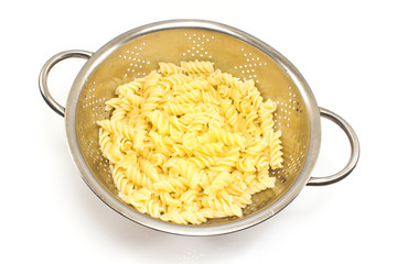Fresh cooked fusilli pasta in strainer isolated on white