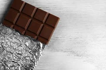 Dark Chocolate bar in foil  on gray background