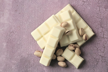White chocolate pieces with nuts on color wooden background
