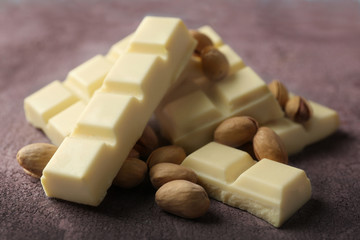 White chocolate pieces with nuts on color wooden background