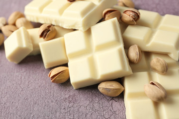 White chocolate pieces with nuts on color wooden background