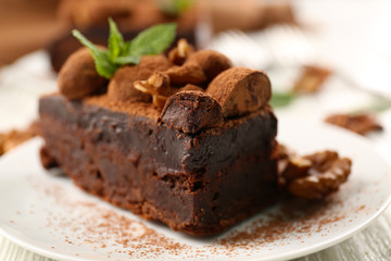 Piece of chocolate cake with walnut and mint on the table, close-up
