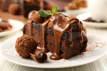 A piece of chocolate cake with mint on the table, close-up