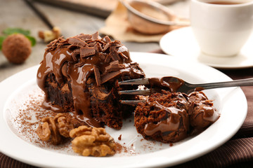 A piece of chocolate cake with walnut on the table, close-up