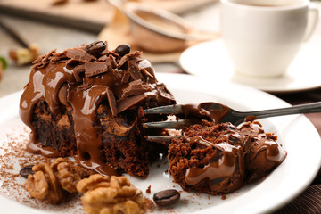 A piece of chocolate cake with walnut on the table, close-up