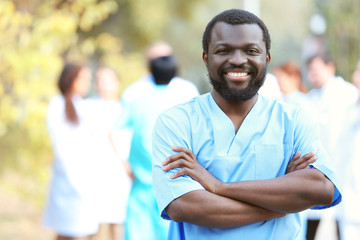 Portrait of an handsome smiling doctor on blurred background