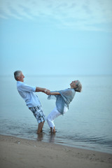 Elderly couple walking along  seashore