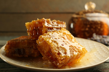 Honeycombs on plate on wooden background