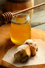 Fresh sweet bread with honey on wooden background
