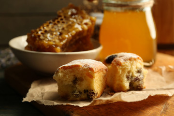 Honeycombs on plate, hot buns on wooden background