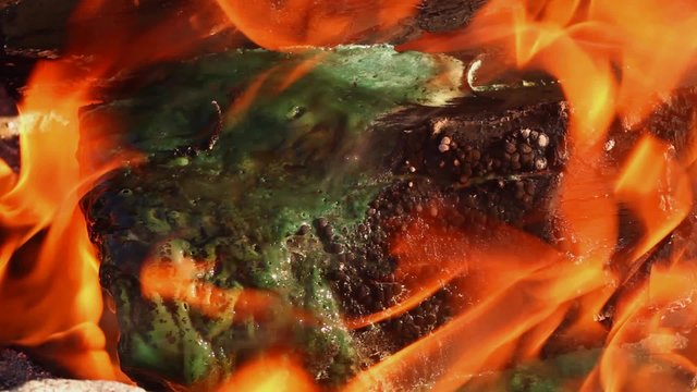 Plastic material burning, melting and dissolving in fire; close up; no people; 