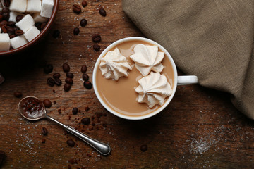 Cup of coffee with sweets on wooden background