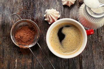 Cup of coffee with sweets on wooden background