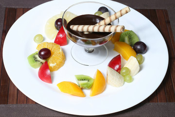 fruit apples, kiwi, bananas, pineapples, grapes with syrup