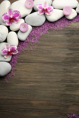Spa stones and orchid on wooden background