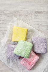 Pastel red, violet, green and yellow marshmallow on craft paper