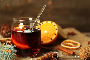 Mulled wine in glass bank on decorated wooden table
