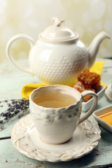 Honeycomb, bowl with honey, teapot on color wooden background