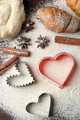 Heart of flour, croissant and spices on gray background