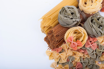 Different types of italian pasta. Whole spaghetti, farfalle pasta and pasta fettuccine nests isolated on white background