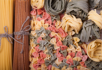 Different types of italian pasta. Whole spaghetti, farfalle pasta and pasta fettuccine nests