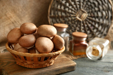 Mushrooms in basket on wooden surface