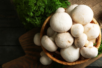Mushrooms in basket on wooden surface