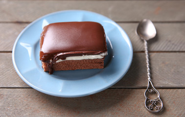 Delicious chocolate brownies on plate, on wooden background
