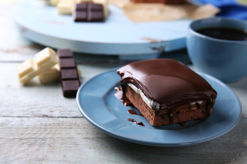 Delicious chocolate brownie on plate on wooden background