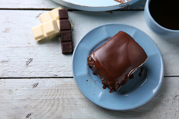 Delicious chocolate brownie on plate on wooden background