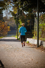 Obraz premium Woman running in a park in autumn