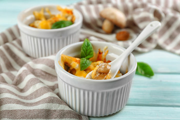 French dish julienne. Mushroom, chicken and cheese gratin in ceramic bowls, on wooden background