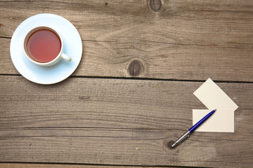 Blank business cards with pen and tea cup on wooden office table