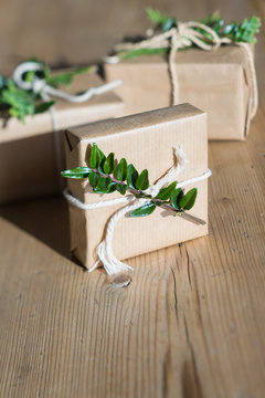 Simple gift wrapping idea: kraft paper, evergreen plants and twine. Selective focus
