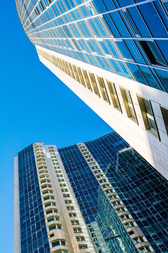 High-rise residential building on a background of blue sky. Photo from a lower angle.
