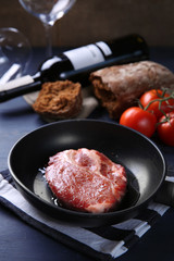 Marbled beef steak and wine bottle on wooden background