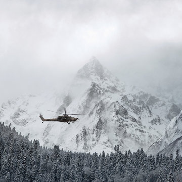 Combat helicopter over the winter mountains