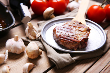 Roasted beef fillet on plate, on wooden background