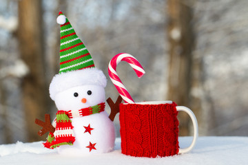 Snowman with red mug and candy