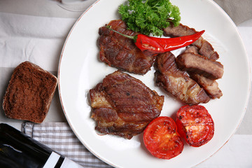 Roasted beef fillet and grilled vegetables on plate, on wooden background