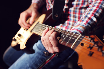 Fototapeta na wymiar Young man playing on electric guitar close up