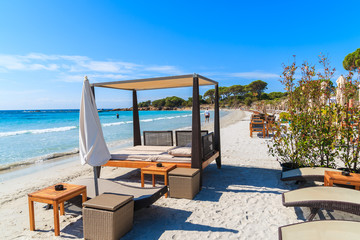 Sunbeds on beautiful white sand Palombaggia beach, Corsica island, France
