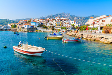 Vissersboten in de baai van Kokkari met kleurrijke huizen op de achtergrond, het eiland Samos, Griekenland