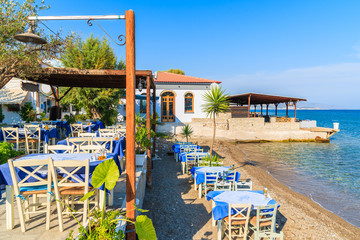 Tables with chairs in Greek tavern on sea coast, Samos island, Greece