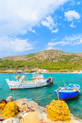 Fototapeta na wymiar Colorful Greek fishing boats with nets on shore in Posidonio bay, Samos island, Greece