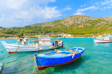 Fototapeta na wymiar Colorful Greek fishing boats on shore in Posidonio bay, Samos island, Greece
