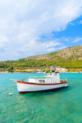 Fototapeta na wymiar Traditional Greek fishing boat on turquoise sea water in Posidonio bay, Samos island, Greece